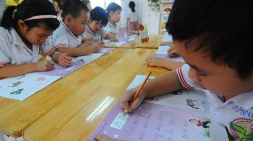 Ở độ tuổi mẫu giáo, trẻ chỉ được yêu cầu nhận diện con số và 29 chữ cái. Trong ảnh: học sinh lớp lá Trường mầm non Anh Đào (Q.Gò Vấp, TP.HCM) tập tô, tập tính chiều 26-4. Ảnh: T.T.D.