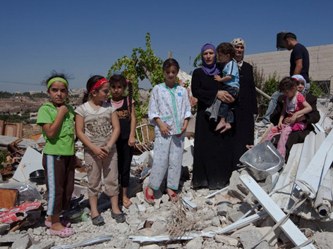 Một gia đình Palestine đứng trên nền ngôi nhà của họ ở khu dân cư Beit Hanina bị chính quyền Israel đập nát tháng 7/2009. Ảnh: Truth News