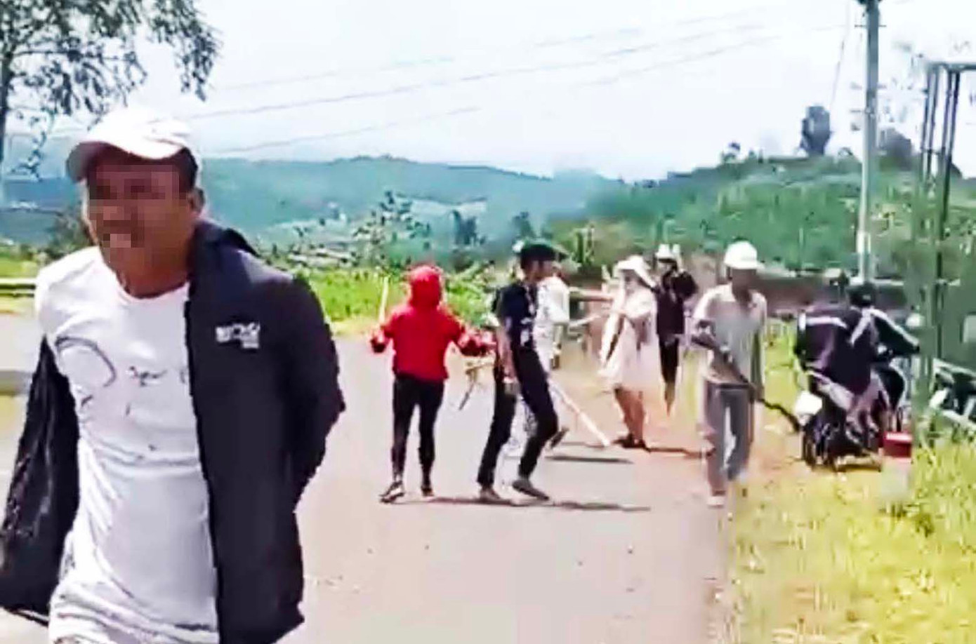 Dùng rựa và gậy truy đuổi, chém người bị thương. Ảnh cắt từ clip Dùng rựa và gậy truy đuổi, chém người bị thương. Ảnh cắt từ clip