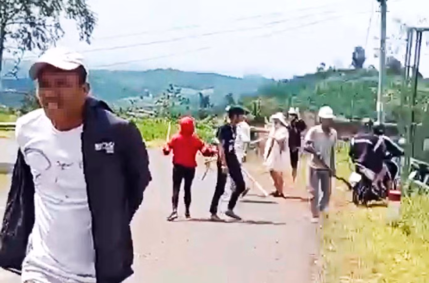 Dùng rựa và gậy truy đuổi, chém người bị thương. Ảnh cắt từ clip