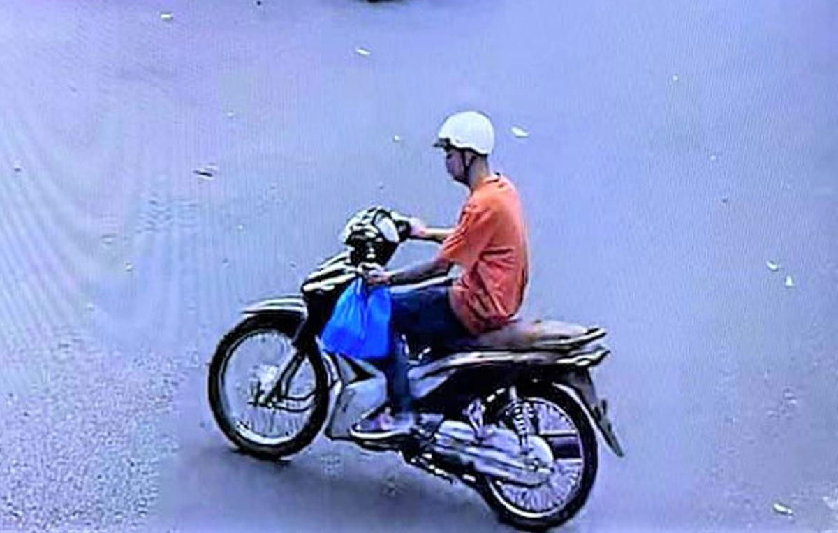 Vũ điều khiển xe máy mang theo cái túi màu xanh đựng 950 triệu đồng vừa trộm được. Ảnh chụp màn hình camera ghi lại.