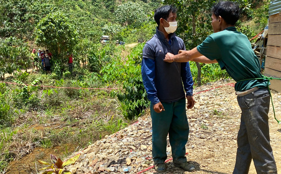 Lực lượng chức năng đưa K'H. (bên phải) đi dựng lại hiện trường vụ án