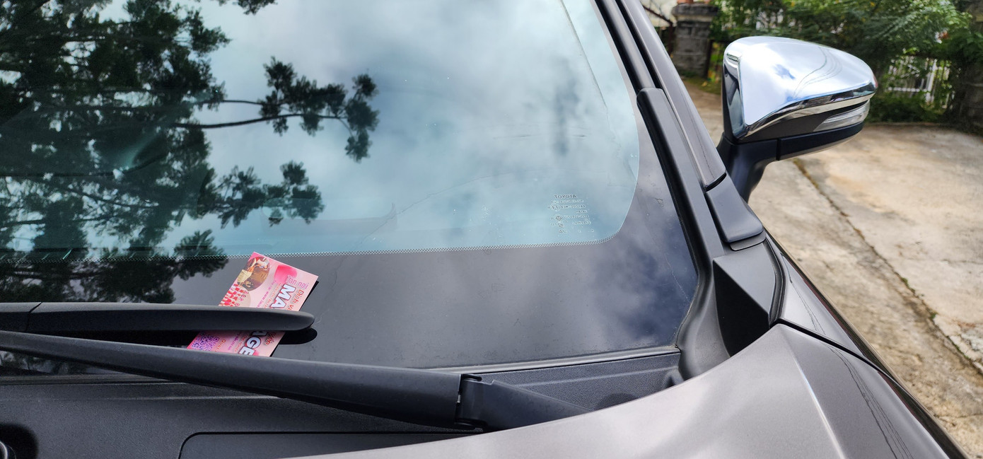 Hai đối tượng cài danh thiếp trên những chiếc ô tô đậu trên đường phố Hai đối tượng cài danh thiếp trên những chiếc ô tô đậu trên đường phố