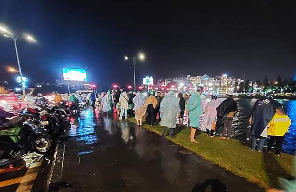 Nhiều người đội mưa theo dõi việc tìm kiếm chiếc ô tô dưới hồ Nhiều người đội mưa theo dõi việc tìm kiếm chiếc ô tô dưới hồ