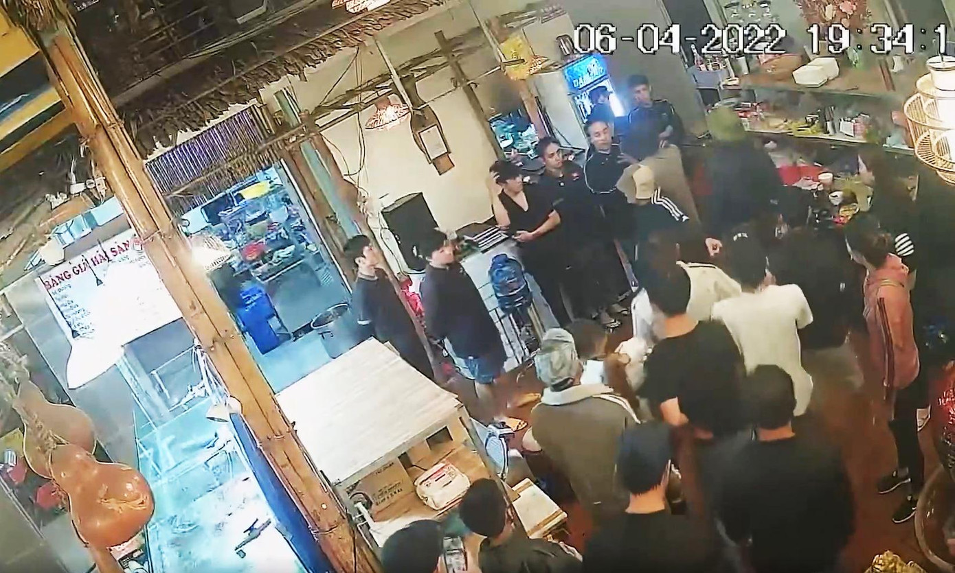 Bắt các nhân viên xếp hàng trước quầy thu ngân để hành hung. Ảnh cắt từ clip