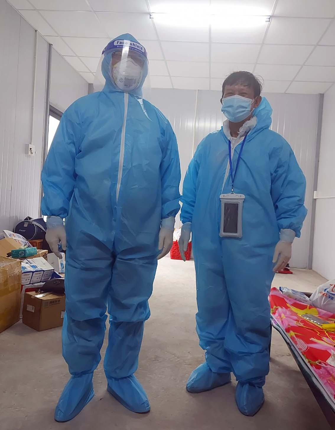 Bác sĩ Sỹ (bìa phải) mặc đồ bảo hộ 2 lớp, chuẩn bị khám cho bệnh nhân mắc COVID-19