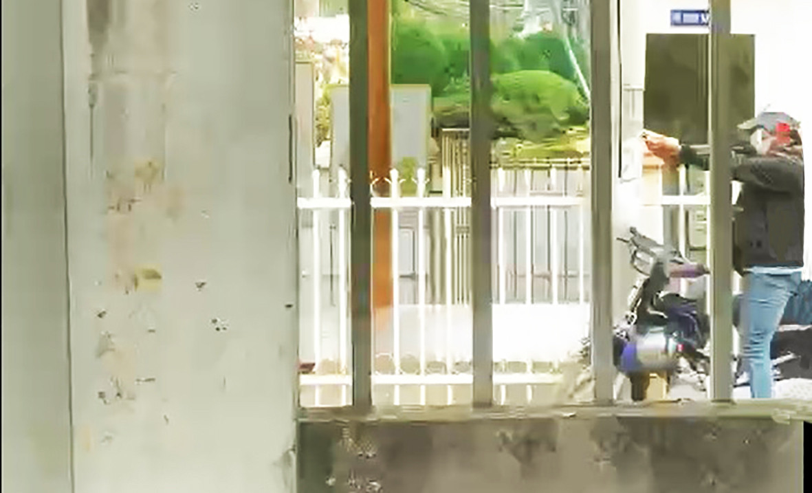 Kẻ cướp chĩa súng về phía bảo vệ ngân hàng bóp cò. Ảnh cắt từ clip Kẻ cướp chĩa súng về phía bảo vệ ngân hàng bóp cò. Ảnh cắt từ clip