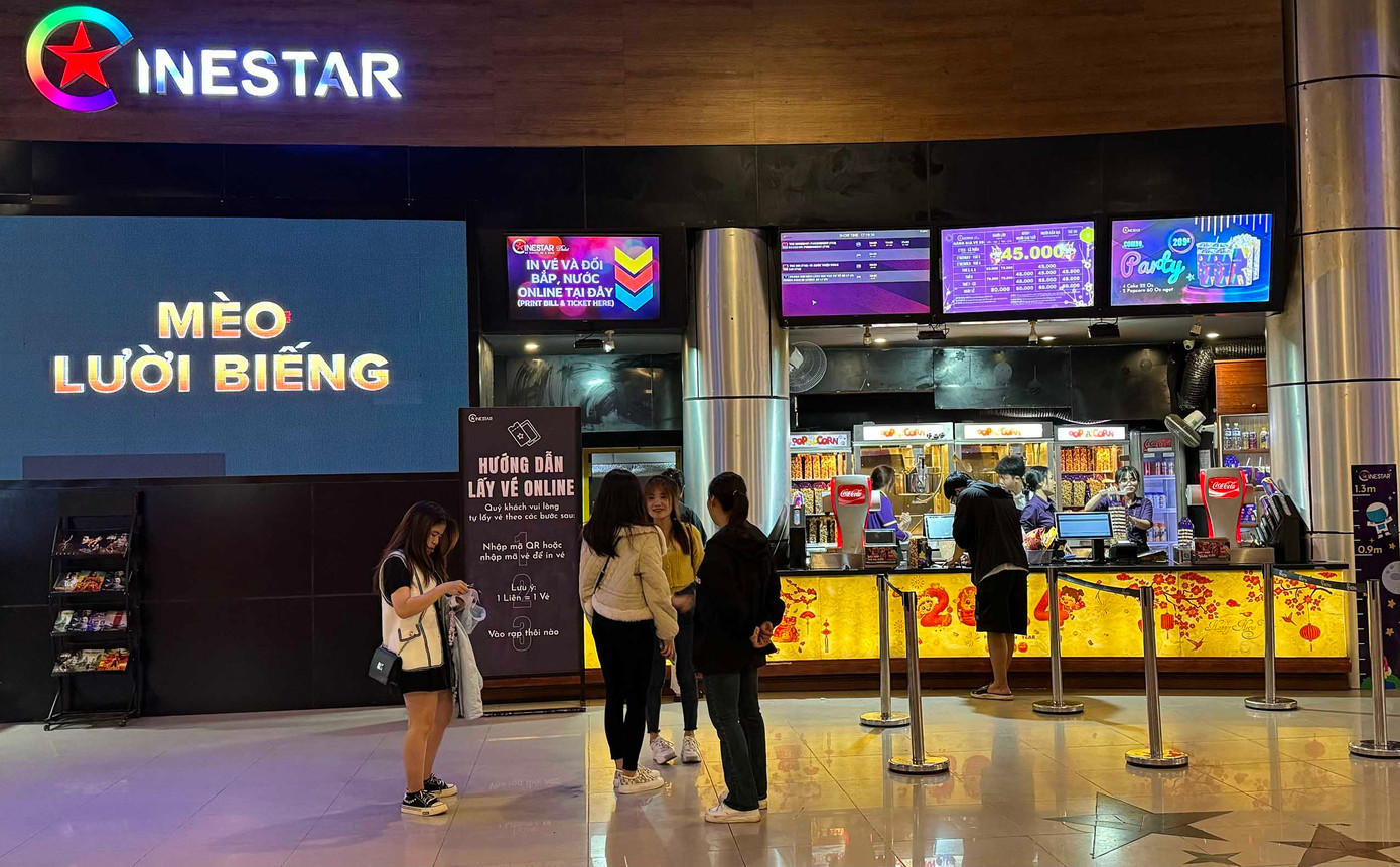 Các bạn trẻ đang mua vé để vào phòng chiếu phim.