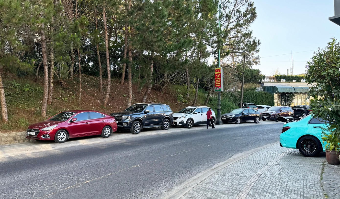 Nhiều ô tô đậu trên lề đường Hồ Tùng Mậu khiến người đi bộ phải lưu thông dưới lòng đường