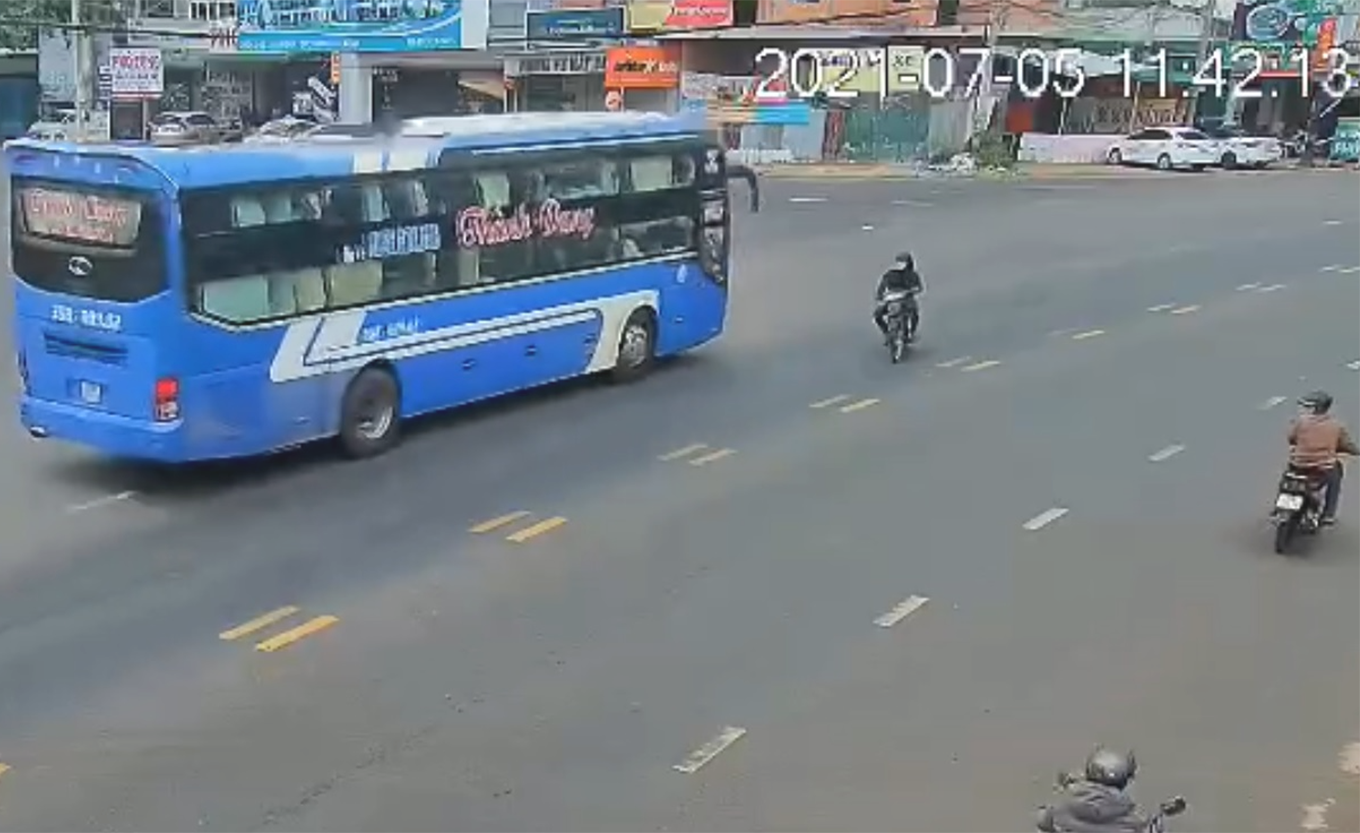 Người điều khiển xa máy nhanh tay bẻ lái tránh được chiếc xe khách đang tăng tốc. Ảnh cắt từ clip