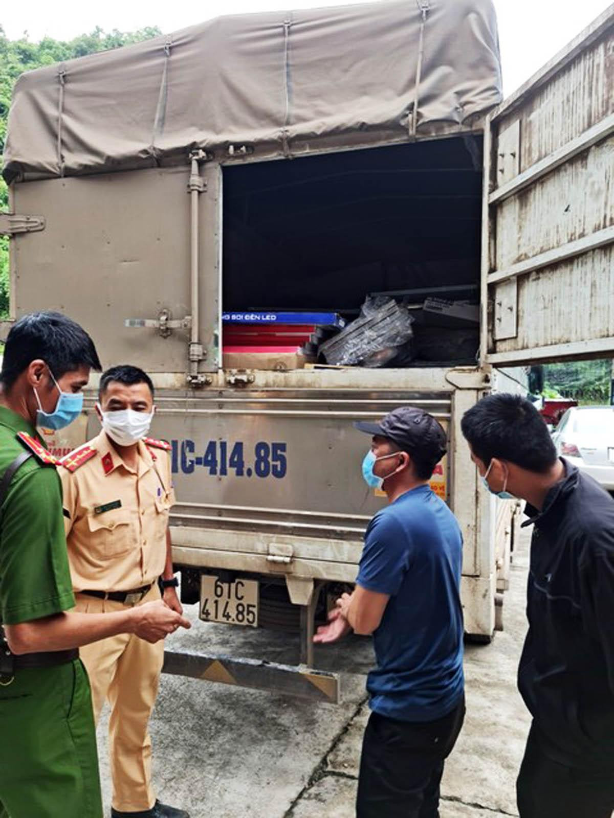 Phụ xe Nguyễn Anh Tiệp (áo thun xanh) bị phát hiện trốn trong thùng xe tải hòng vượt chốt kiểm dịch