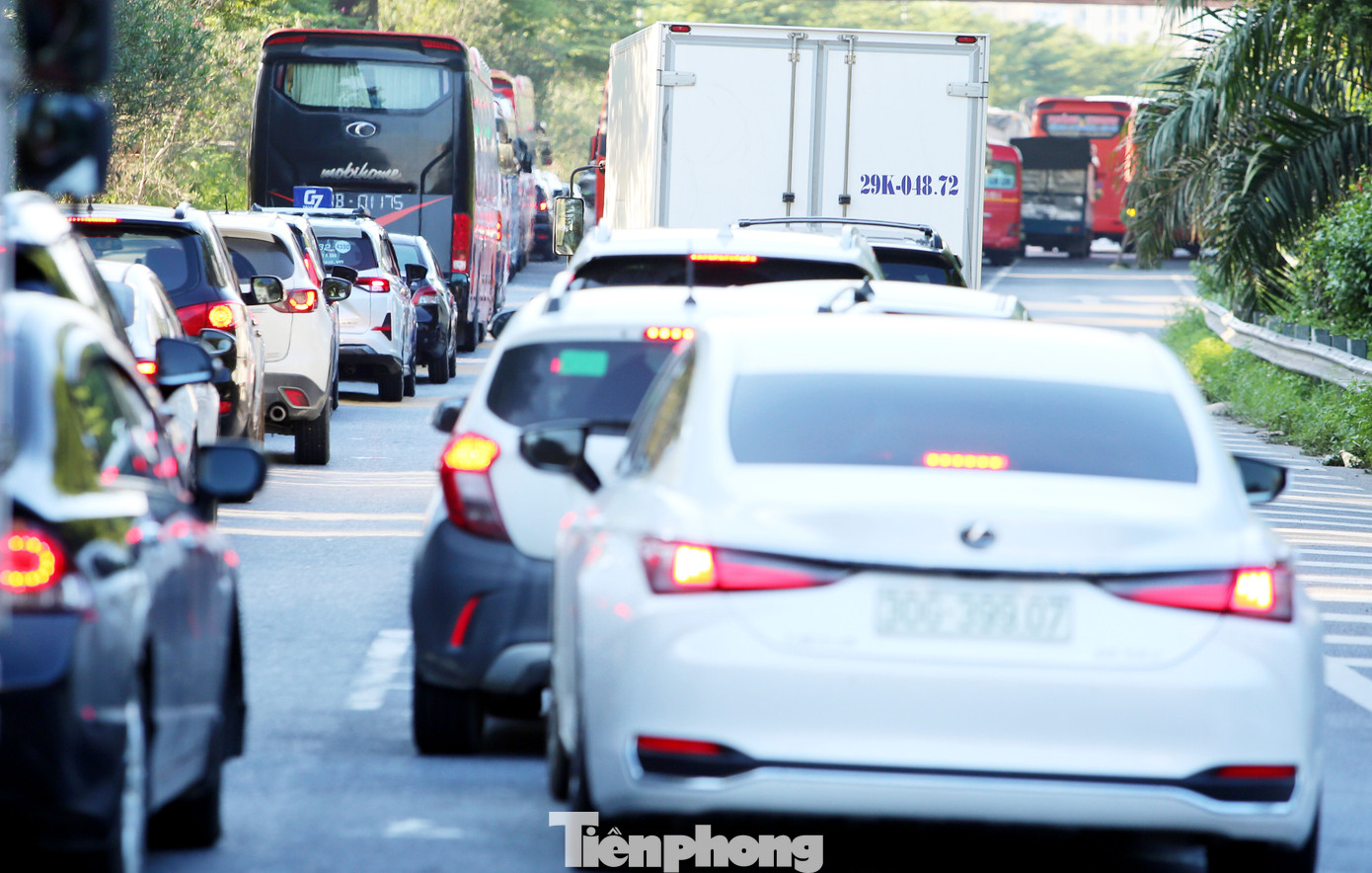 Ô tô xếp thành hàng dài và di chuyển rất chậm qua khu vực ngã tư đèn tín hiệu.