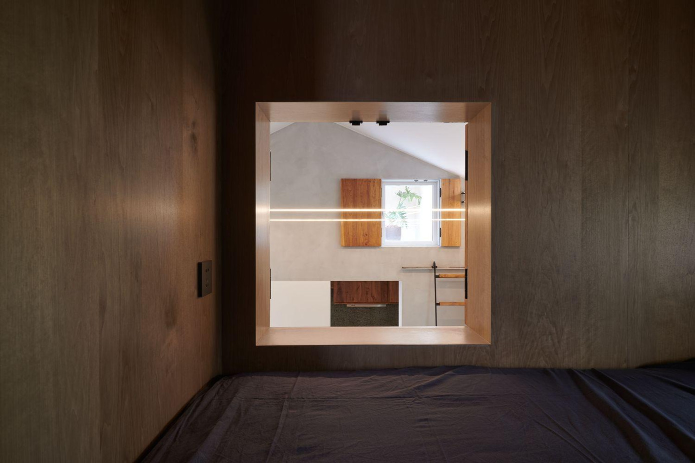 Các kiến trúc sư sử dụng veneer gỗ (ván lạng) để ốp khu vực phòng ngủ, nhằm giảm thiểu sự can thiệp của vật liệu vào trải nghiệm không gian.