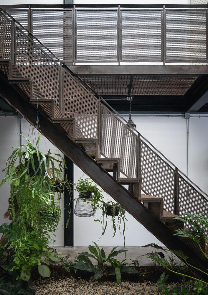 Cạnh khu vườn là cầu thang sắt đục lỗ đồng màu với hệ khung thép nâng đỡ tòa nhà. Cạnh khu vườn là cầu thang sắt đục lỗ đồng màu với hệ khung thép nâng đỡ tòa nhà.
