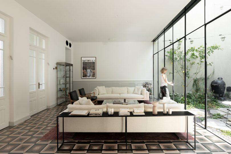 Sân vườn đóng vai trò như một cầu nối giữa không gian ban đầu và phần mở rộng mới. Nó cung cấp thêm ánh sáng tự nhiên và có chức năng như một không gian ngoài trời riêng tư.