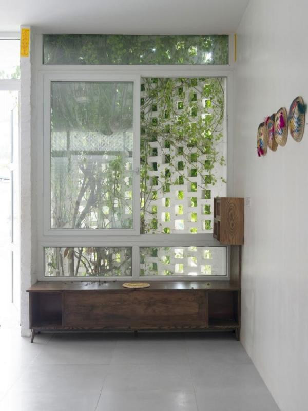 BINH HOUSE (Huyện Thạch Thất, Hà Nội) sử dụng gạch khoét lỗ để cây xanh bám vào, tạo thành bức tường tự nhiên điều hòa nhiệt độ cho cả căn nhà. Màu sơn trắng cũng góp phần giảm phản xạ nhiệt cho tòa nhà và tạo ra nhiệt độ mát hơn mà không cần thêm hệ thống làm mát cơ học. (Ảnh: Internet) BINH HOUSE (Huyện Thạch Thất, Hà Nội) sử dụng gạch khoét lỗ để cây xanh bám vào, tạo thành bức tường tự nhiên điều hòa nhiệt độ cho cả căn nhà. Màu sơn trắng cũng góp phần giảm phản xạ nhiệt cho tòa nhà và tạo ra nhiệt độ mát hơn mà không cần thêm hệ thống làm mát cơ học. (Ảnh: Internet)