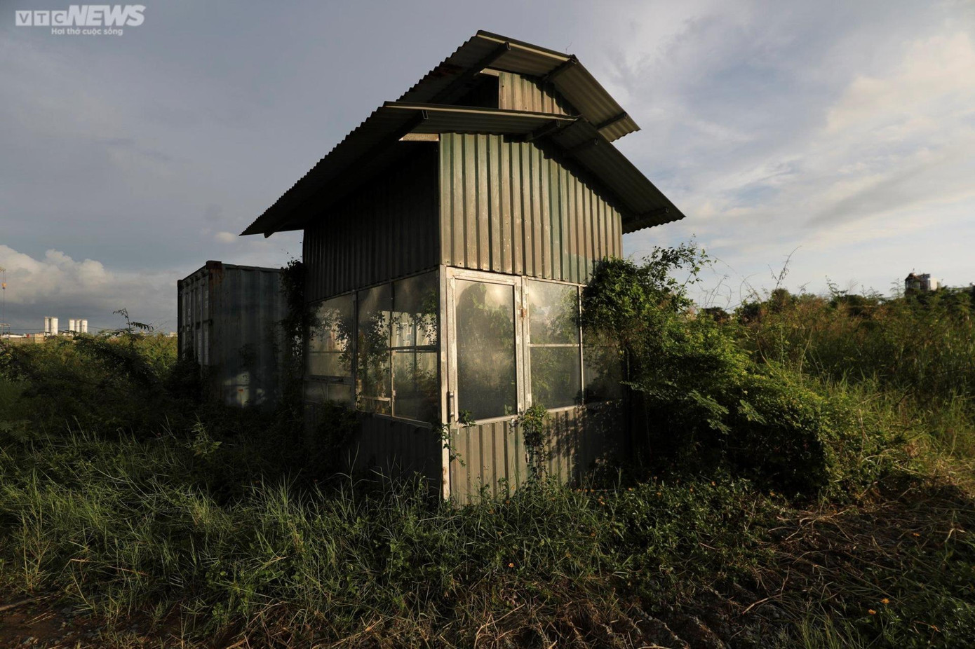 Chòi bảo vệ nằm ngay cổng dự án bị cỏ dại bảo phủ cả bên ngoài và bên trong. Chòi bảo vệ nằm ngay cổng dự án bị cỏ dại bảo phủ cả bên ngoài và bên trong.
