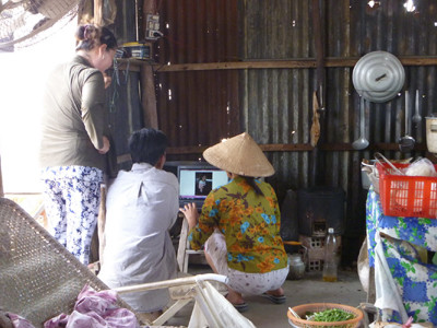 Gia đình chị quán cơm tranh thủ xem ảnh bằng... laptop. Gia đình chị quán cơm tranh thủ xem ảnh bằng... laptop