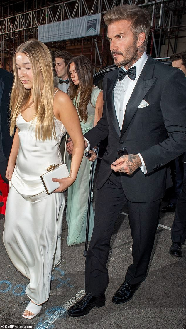 David Beckham bảnh bao, phong độ với lễ phục đen cổ điển. Trong khi đó, Harper Seven ra dáng thiếu nữ với váy hai dây satin và dép cao gót. Ảnh: GoffPhoto.