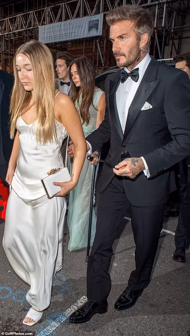 David Beckham bảnh bao, phong độ với lễ phục đen cổ điển. Trong khi đó, Harper Seven ra dáng thiếu nữ với váy hai dây satin và dép cao gót. Ảnh: GoffPhoto.