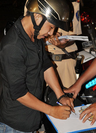 Người vi phạm ký biên bản. Ảnh: Quốc Thắng