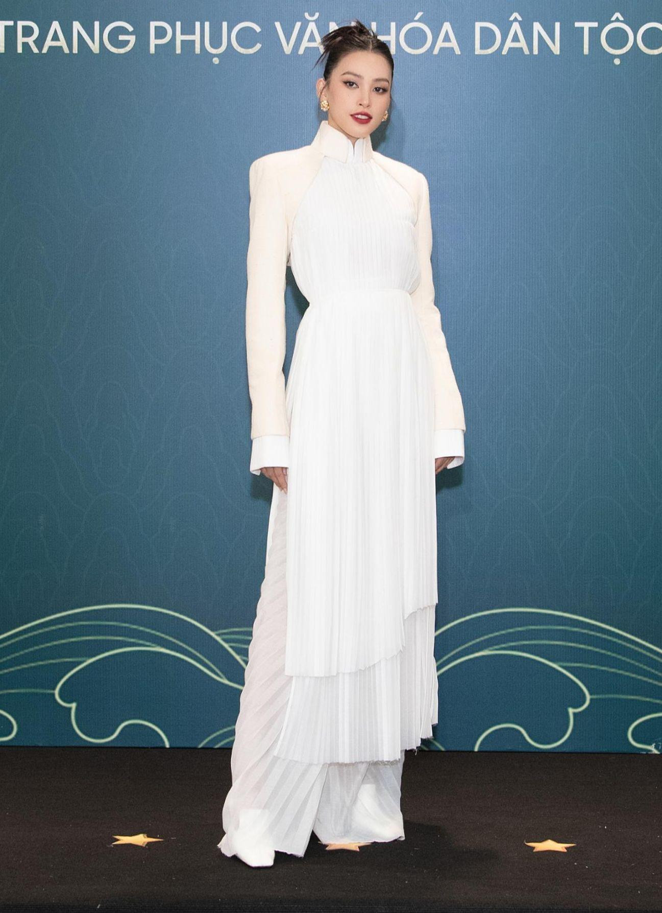 Hoa hậu Việt Nam 2018 Trần Tiểu Vy lựa chọn áo dài truyền thống tone trắng tinh khiết. Những chi tiết xếp ly cách điệu ở phần tà cùng điểm nhấn khoác lửng giúp tổng thể thêm phần cá tính.