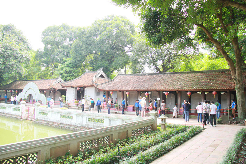 Rất nhiều sinh viên tình nguyện làm nhiệm vụ ngăn cản sĩ tử sờ đầu rùa, sờ bia tiến sỹ trong Văn Miếu. Ảnh: Trường Phong