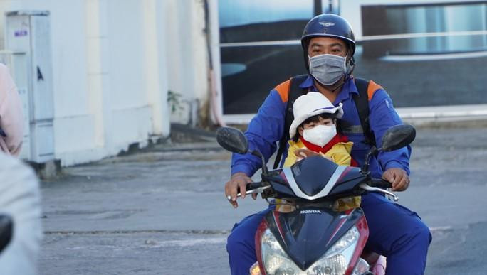 Trẻ em được phụ huynh cho ăn mặc kín khi đi trên đường Trẻ em được phụ huynh cho ăn mặc kín khi đi trên đường