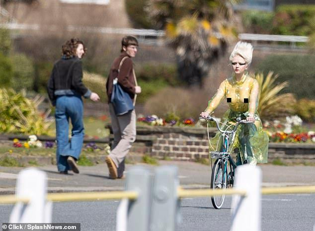 Maisie khiến người đi đường phải ngoái nhìn khi mặc áo trong suốt màu vàng, phô bày hoàn toàn thân trên với vòng một không có nội y che chắn.