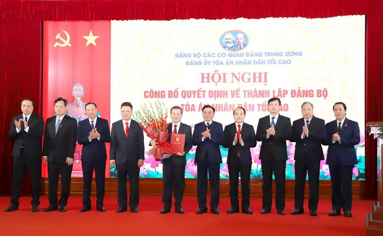 Ủy viên Bộ Chính trị, Thường trực Ban Bí thư, Bí thư Đảng ủy các cơ quan Đảng Trung ương Trần Cẩm Tú trao quyết định và tặng hoa chúc mừng các đồng chí trong Ban Thường vụ Đảng ủy TANDTC.