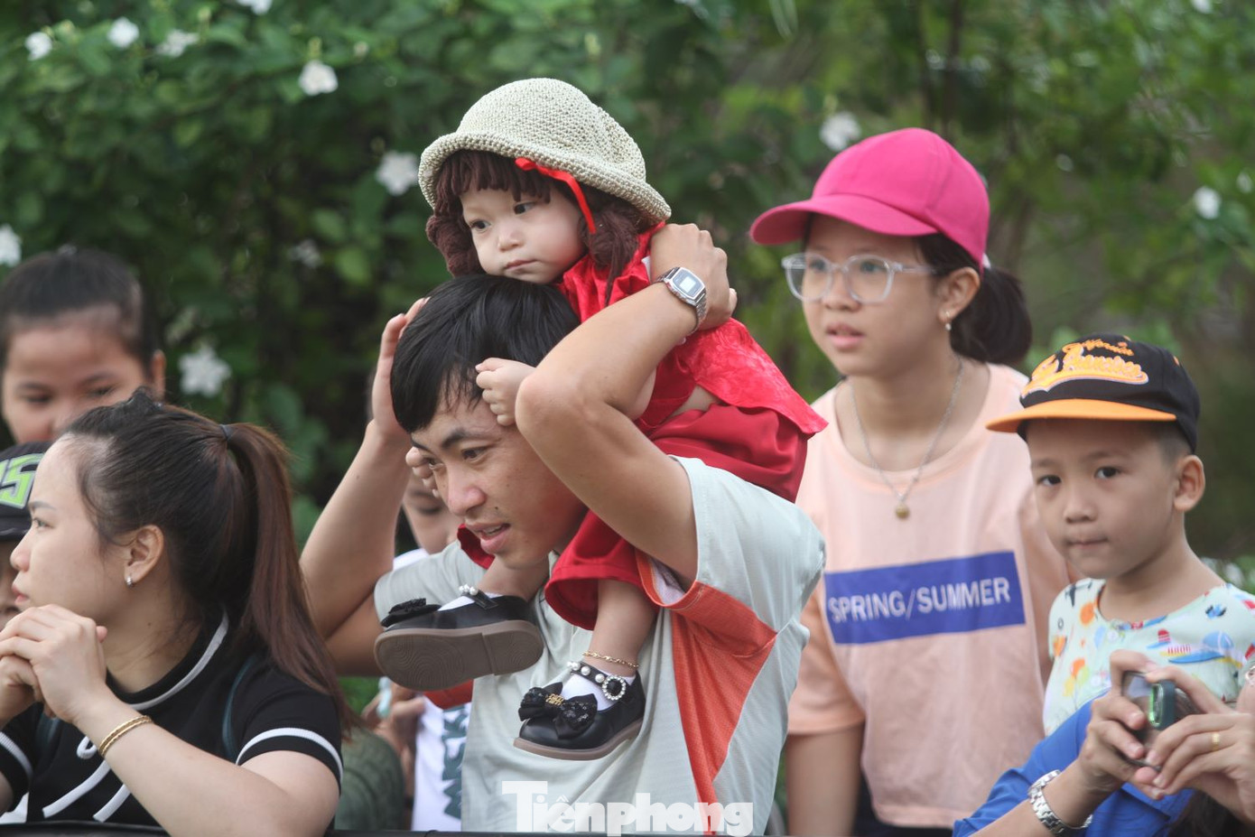 Nhiều em bé được cha, mẹ cho đến xem đua thuyền.