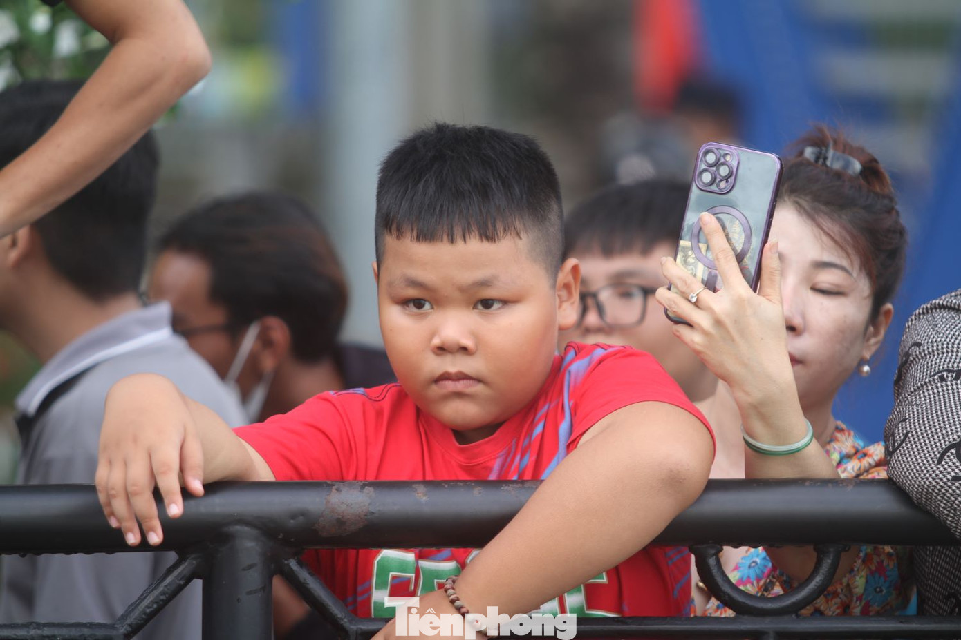 Bé trai chăm chú xem đua thuyền
