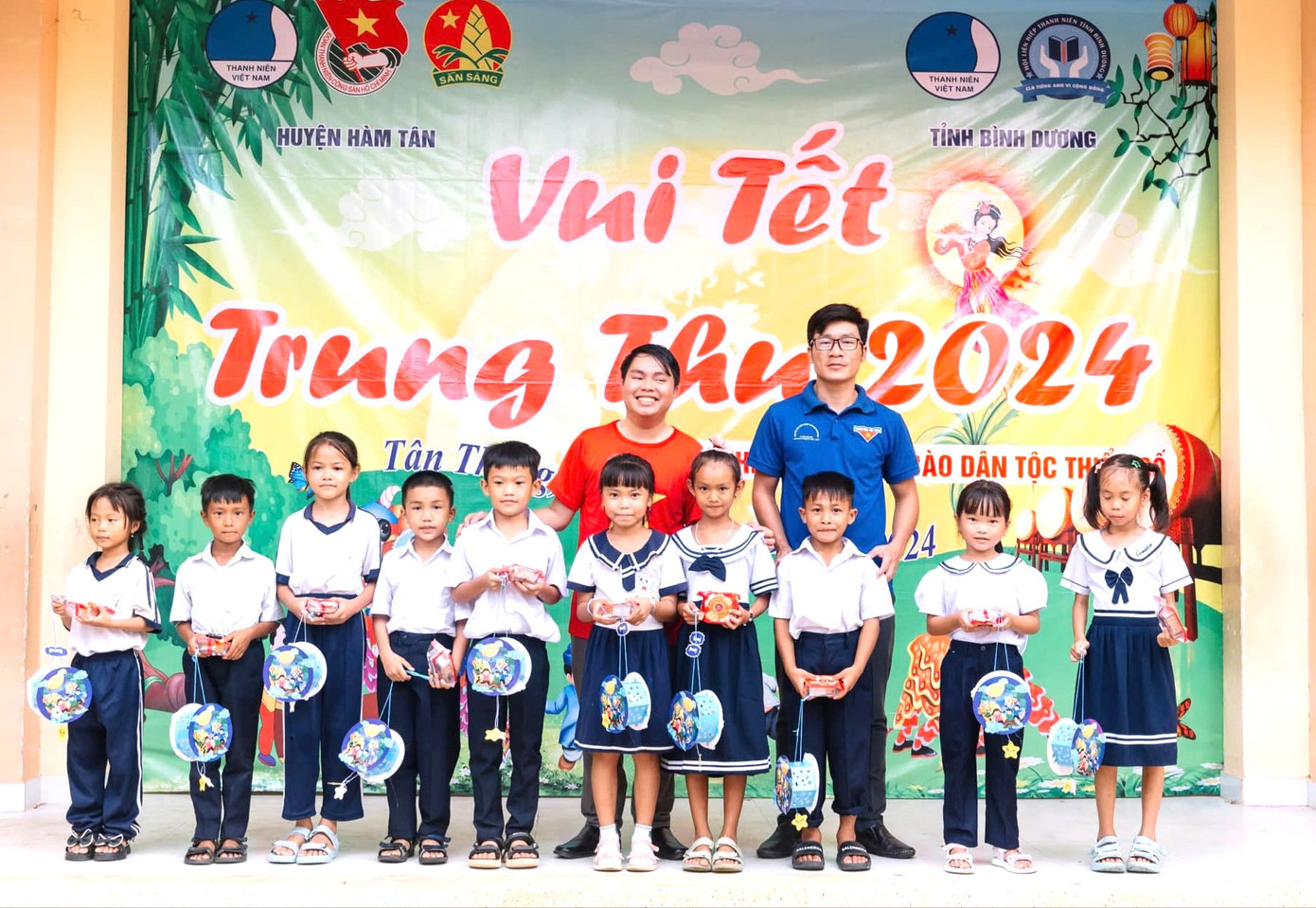 Các em thiếu nhi nhận lồng đèn, bánh trung thu từ các anh, chị đoàn viên thanh niên. Ảnh: Chấn Sang