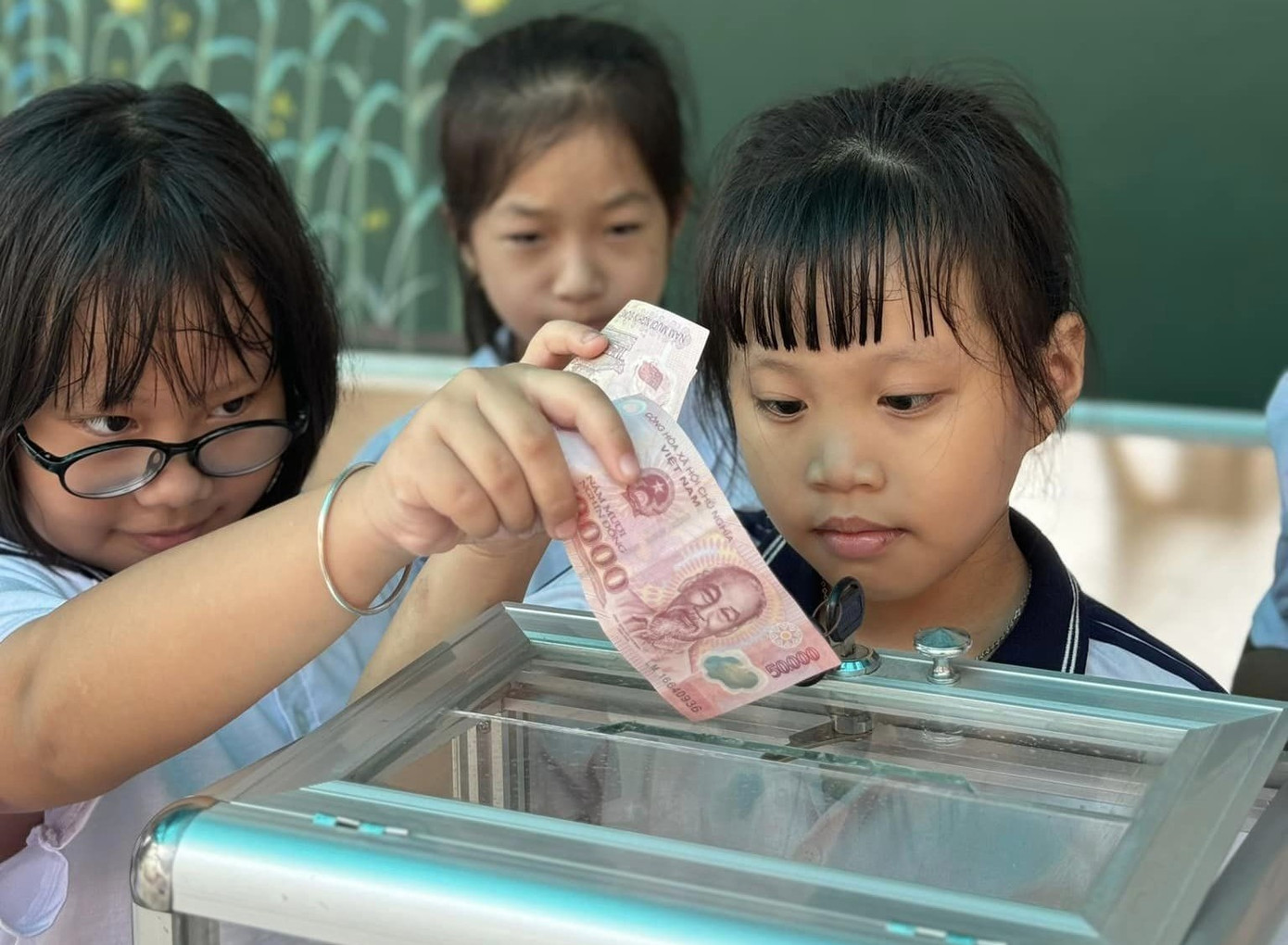 Nhiều em học sinh dùng tiền tiết kiệm được để mang đến trường ủng hộ