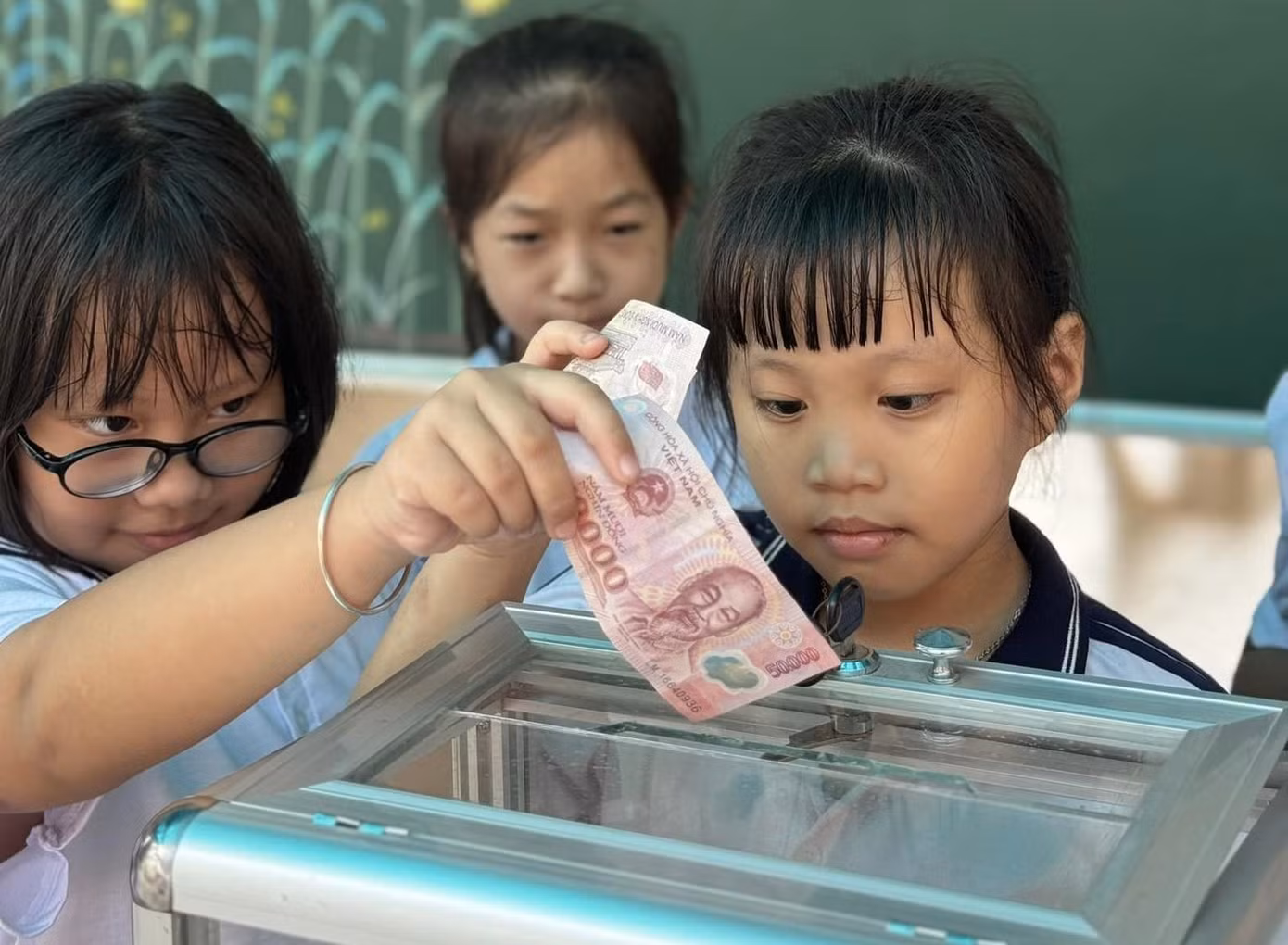 Nhiều em học sinh dùng tiền tiết kiệm được để mang đến trường ủng hộ