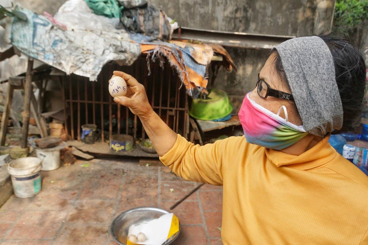 Bà Lưu tò mò kiểm tra trứng xem có điều gì khác biệt. Bà Lưu tò mò kiểm tra trứng xem có điều gì khác biệt.