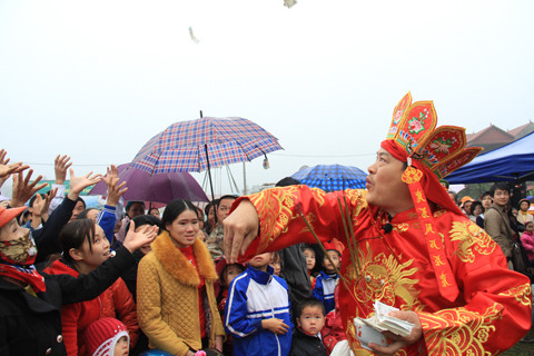 Sau khi làm lễ, thầy cúng phát lộc cho người dân. Ảnh: Trường Phong