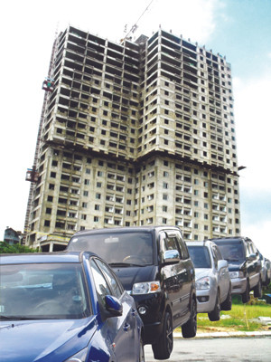 Một cao ốc dành cho người thu nhập thấp (ảnh trên) Đoàn xe của những người đi đăng ký mua nhà dành cho người thu nhập thấp ở Hà Nội) (ảnh dưới)