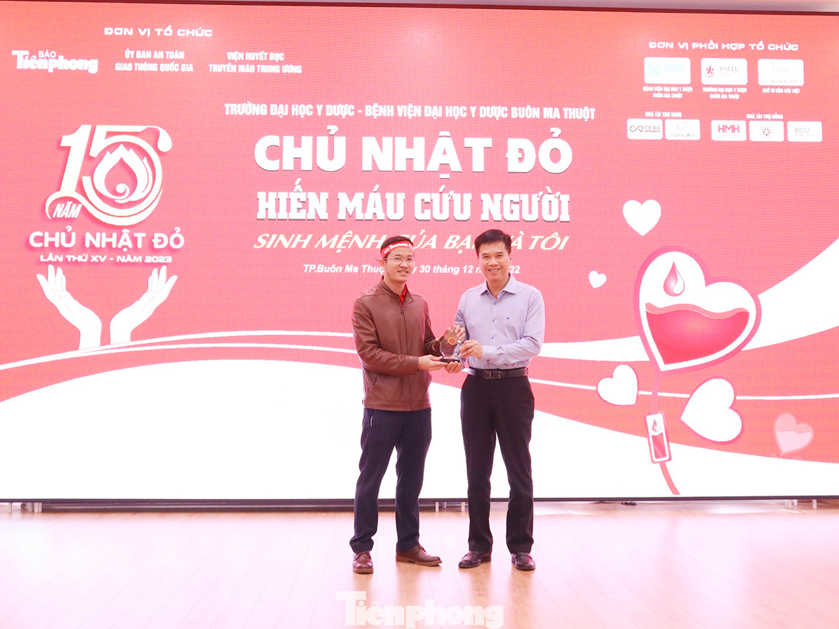 Nhà báo Tuấn Nguyễn (trái) trao kỷ niệm chương cho đại diện lãnh đạo Trường ĐH Y Dược Buôn Ma Thuột