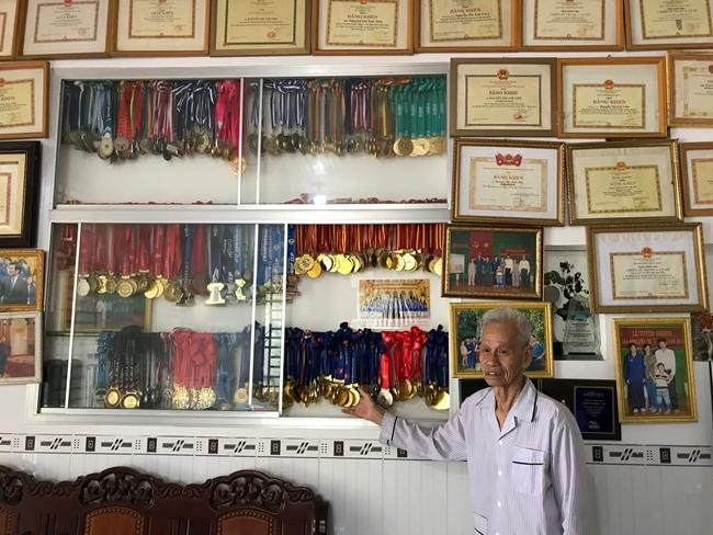 Ông của Ánh Viên bên những tấm huy chương của cháu gái.