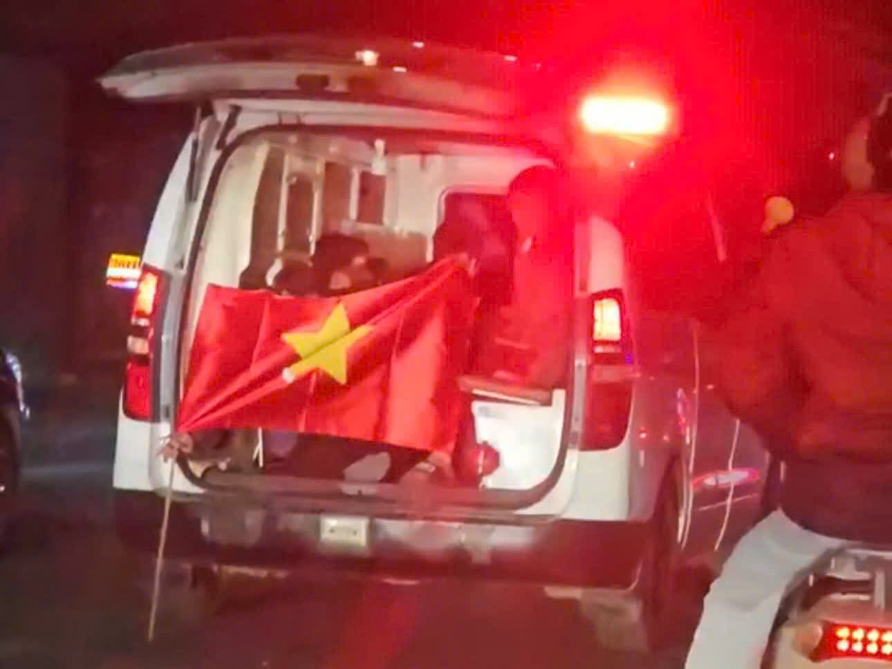 Hình ảnh xe cứu thương bật thiết bị ưu tiên, chở cổ động viên bóng đá.