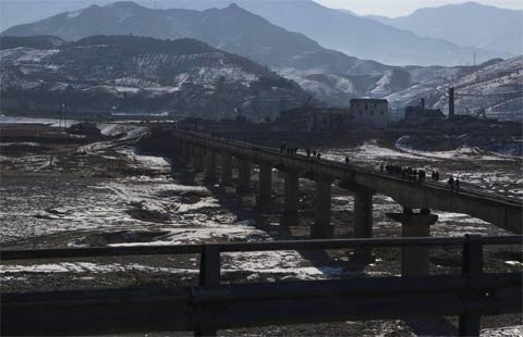 Người dân đi trên một cây cầu đường sắt bắc qua sông ở phía nam núi Myohyang và phía bắc thủ đô Bình Nhưỡng ngày 23/2