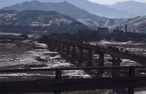 Người dân đi trên một cây cầu đường sắt bắc qua sông ở phía nam núi Myohyang và phía bắc thủ đô Bình Nhưỡng ngày 23/2