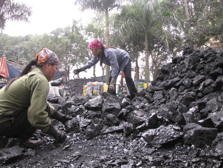 Chị Nguyễn Thị Hà (bên trái) và chị Phạm Thị Xuân làm việc tại một xưởng than trên đường Hồ Mễ Trì (Hà Nội) ngày 8 - 3