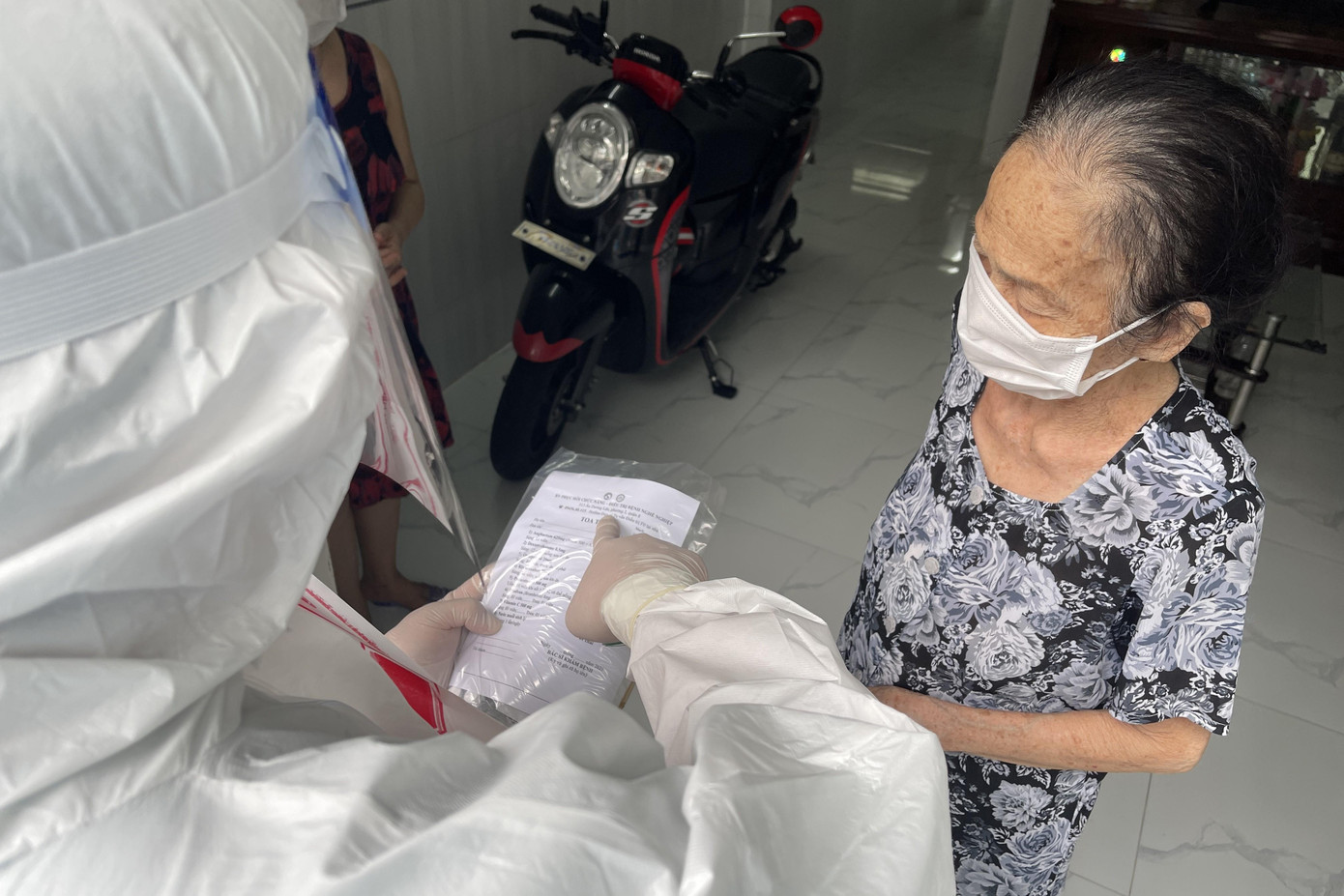 Nhân viên y tế phát túi thuốc cho bệnh nhân COVID-19 điều trị tại nhà ở TPHCM