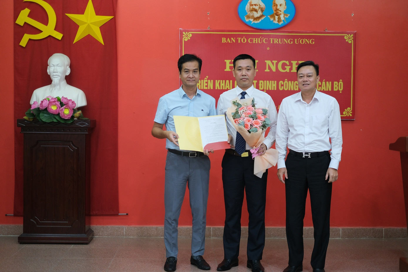 Đồng chí Phạm Thanh Bình - Vụ trưởng Vụ Tổ chức - Cán bộ, Ban Tổ chức Trung ương (ngoài cùng bên trái) trao quyết định và đồng chí Nguyễn Văn Phóng - Vụ trưởng Vụ Địa phương III (ngoài cùng bên phải) tặng hoa đồng chí Nguyễn Văn Hòa. Ảnh: Chinhphu.vn.