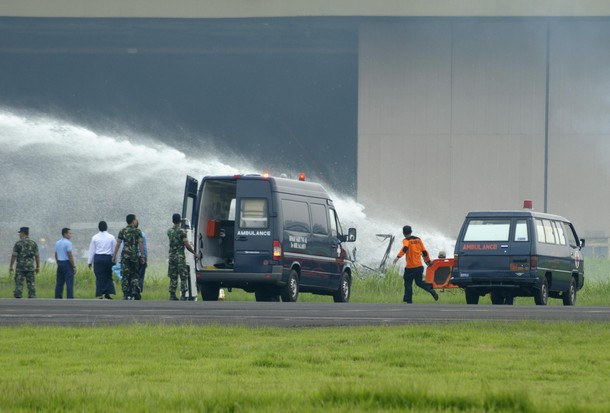 Lực lượng cứu hộ đang phun nước dập tắt đám cháy trên chiếc máy bay - ảnh: Reuters