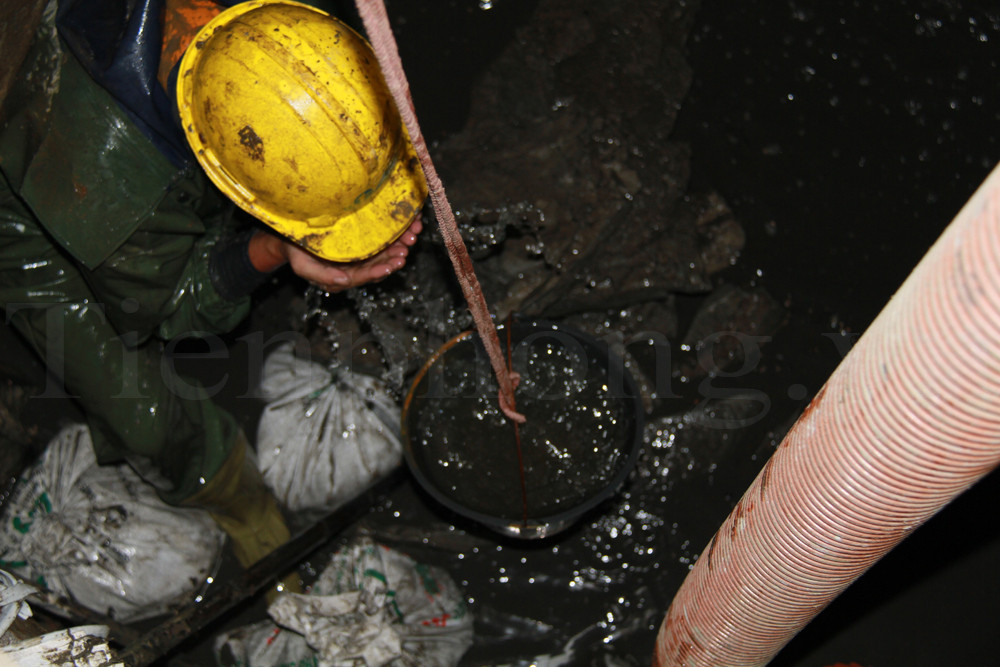 Một thùng nước được thả từ trên xuống cho anh Sơn rửa mặt. Ảnh: Trường Phong