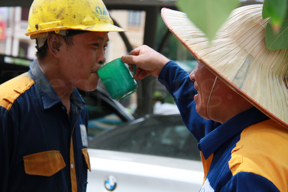 Anh Nguyễn Anh Tuấn được đồng nghiệp múc nước cho uống. Ảnh: Trường Phong