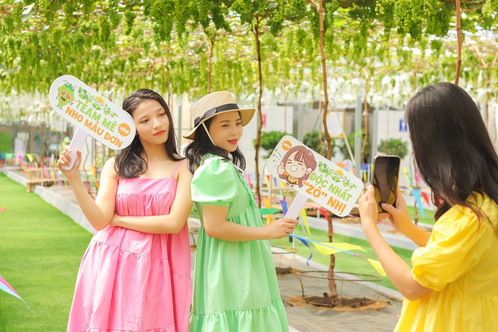 Nhóm bạn trẻ trong trang phục với chủ đề theo Trend “Hoa Bỉ Ngạn” thích thú chụp hình tại vườn nho mẫu đơn.